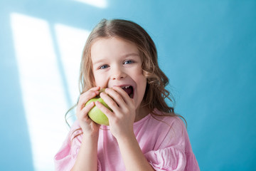 little girl eating a Green Apple fruit vitamins
