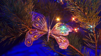 Silver shiny butterfly on the Christmas tree, the concept of the New Year holiday and Christmas