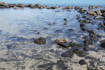 stones in the clear water at the beach