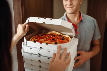 Tuinposter Delivery man shows pizza to customer at the door © Nomad_Soul