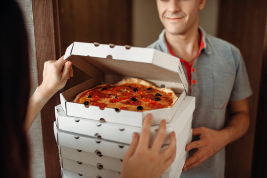 Delivery man shows pizza to customer at the door - Powered by Adobe