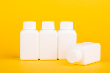 White medical bottles, on yellow background
