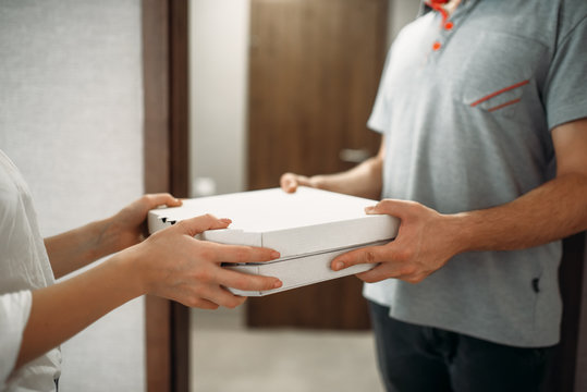 Pizza delivery man gives box to female client