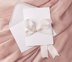 Wedding invitation mockup with ribbons and blush silk