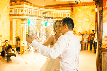 First wedding dance of newlywed. Bride and groom dancing first dance. Fireworks around.
