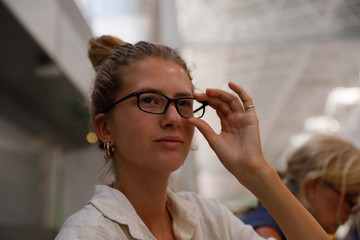 Young woman, authentic, natural, unplugged, waiting for her flight at the airport of Tenerife while eating a bun.