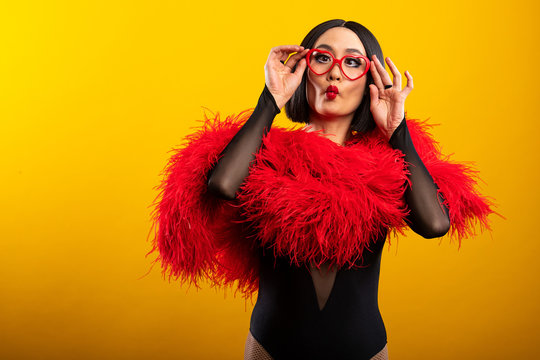 Pretty Asian woman wearing vibrant red feather boa and heart shaped glasses