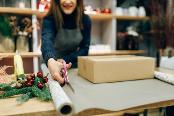 Female person cuts wrapping paper, gift decoration