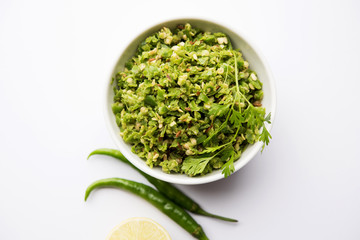 Hot and spicy green chilli chutney using hari mirch, cumin seeds, lemon juice and coriander. served in a bowl. selective focus