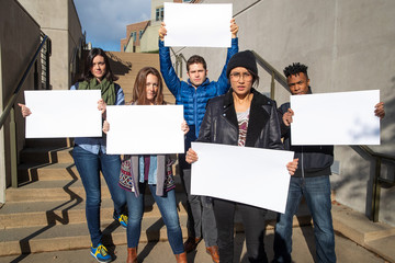 Diverse group of people protesting with blank sign