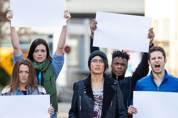 Diverse group of people protesting with blank sign