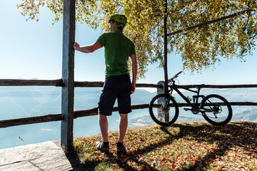 Mountainbiker blickt vom Berg Cimetta über Locarno, Ascona und den Lago Maggiore, Tessin, Schweiz.