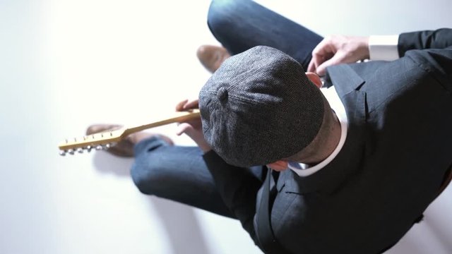 Man with a hat playing electric guitar in the studio