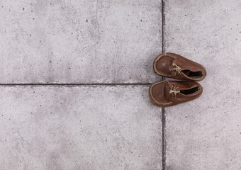 old kids shoes on concrete