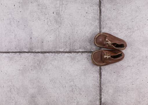 Old Kids Shoes On Concrete