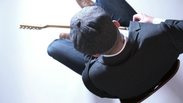Man with a hat playing electric guitar in the studio