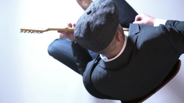 Man with a hat playing electric guitar in the studio