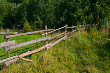 Fototapeta na wymiar Wooden fence on meadow