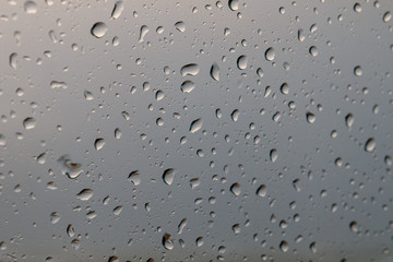 Rain drops on glass or windows show cloud reflection at winter