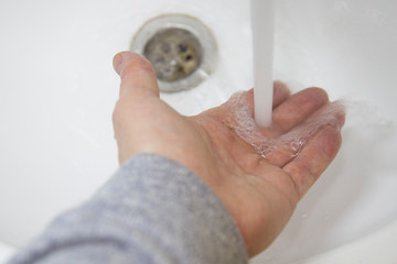 man washes his hands