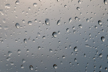 Rain drops on glass or windows show cloud reflection at winter