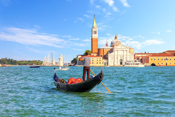 Fototapeta na wymiar Gondolier in a gondola near San Giorgio Maggiore in Venice, Ital