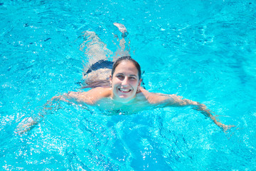 Smiling young woman swimming in a pool