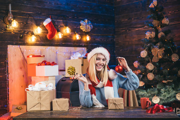 Cute young woman with santa hat. Beauty Model Girl in Santa Hat on home design decorate. Happy people. Merry Christmas and Happy New Year. Christmas woman.