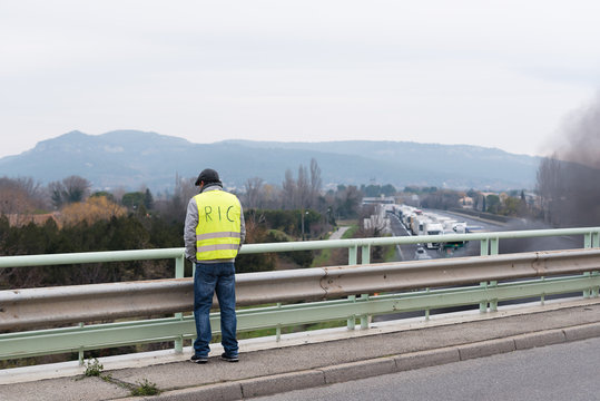 un gilet jaune sur un pont face &agrave; l'autoroute bloqu&eacute;- Ric inscrit dans le dos