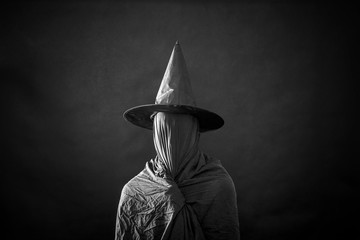 Ghostly figure with long hat in the dark 