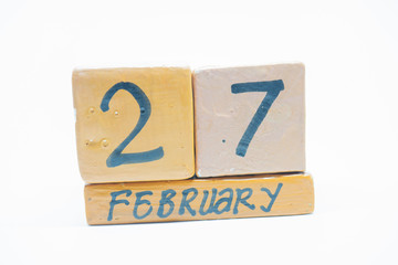 February 27th. Day 27 of month, handmade wood calendar isolated on white background. Winter month, day of the year concept.