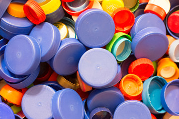 lot of multi-colored plastic bottle caps, close-up. Concept: waste disposal, environmental protection.