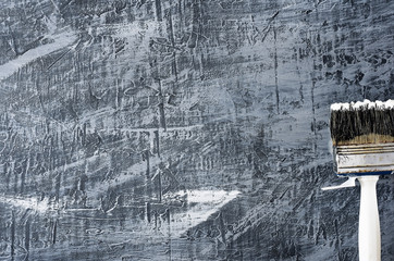 brush in black and white paint on a background of a concrete painted gray background from the right to the bottom