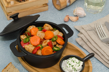 Roasted meat and vegetables in a cast iron pot.  Asian food – pork with vegetables 