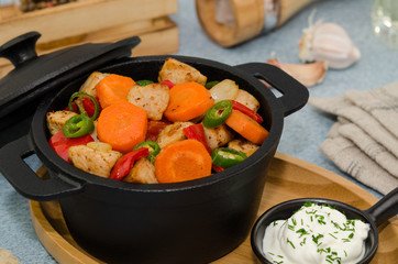 Roasted meat and vegetables in a cast iron pot.  Asian food – pork with vegetables 