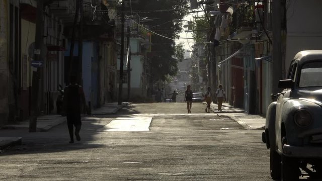 classic American 1950's vintage cars drive on alley street in old Havana neighborhood, Cuba