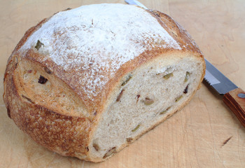 Homemade Olive and Onion Loaf on Cutting Board with Serrated Knife