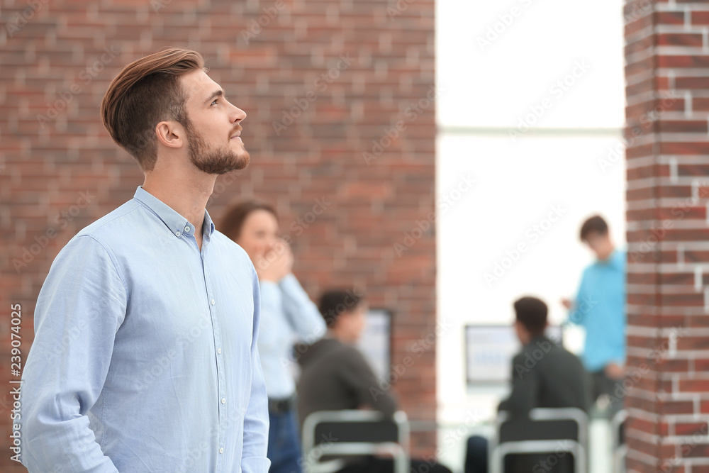 Poster Young businessman looking away while working in the office.