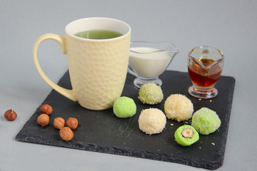 Fat keto peanut butter, cheesecake, matcha balls and keto matcha coconut bulletproof tea in yellow cup. keto protein balls and matcha tea recipes ingredients. it works ketogenic diet. blue background