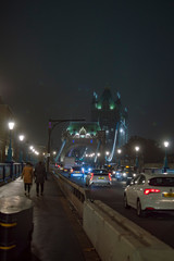 Pedestrians on the road leading to tower bridge in london at night