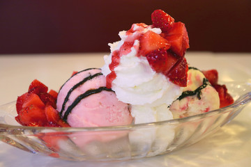 Ice cream sundae top with fresh strawberries and whipped cream 