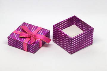 Purple gift box with white dots and red ribbon with bow.