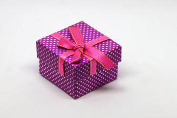 Purple gift box with white dots and red ribbon with bow.