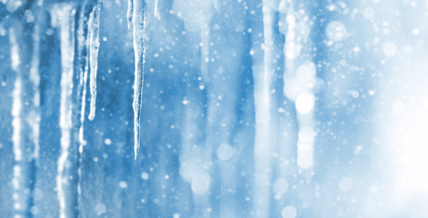Bright background with icicles. Winter background with icicles and falling shiny snow