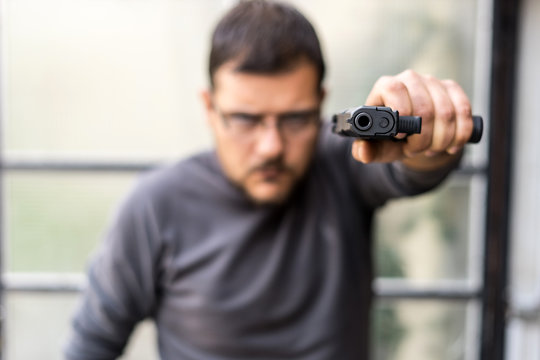 man with gun pointed to the camera
