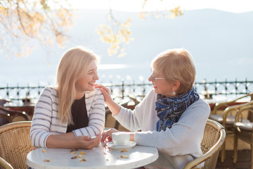 Conversation of two beautiful women in street cafe. Mother and her adult daughter have dialogue...