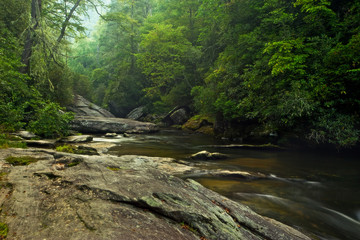 Beautiful Appalachian Mountain forest in North Carolina, with a rocky river cutting through the...