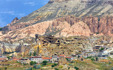 Ancient antique caves and modern settlements in the red valley of Cappadocia, central Turkey.