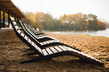 Beach chairs on a sandy river beach in the fall. Warm and calm off-season.