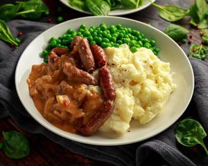 Mashed potatoes and sausages, bangers with onions gravy, green peas